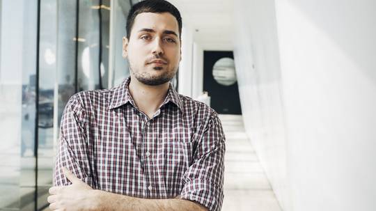 Porträt des Komponisten Veljko Nenadic mit verschränkten Armen im Foyer der Elbphilharmonie