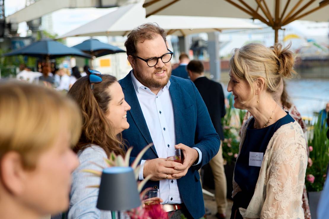 Jenny Svensson unterhält sich mit zwei Personen auf dem Sommerfest.