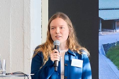 Porträt Alina Wilke mit Mikro beim Vortrag