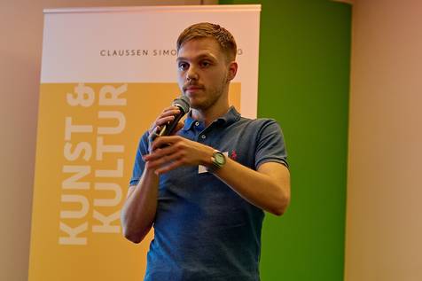 Timon Kollhoff auf einer Bühne mit Mikro